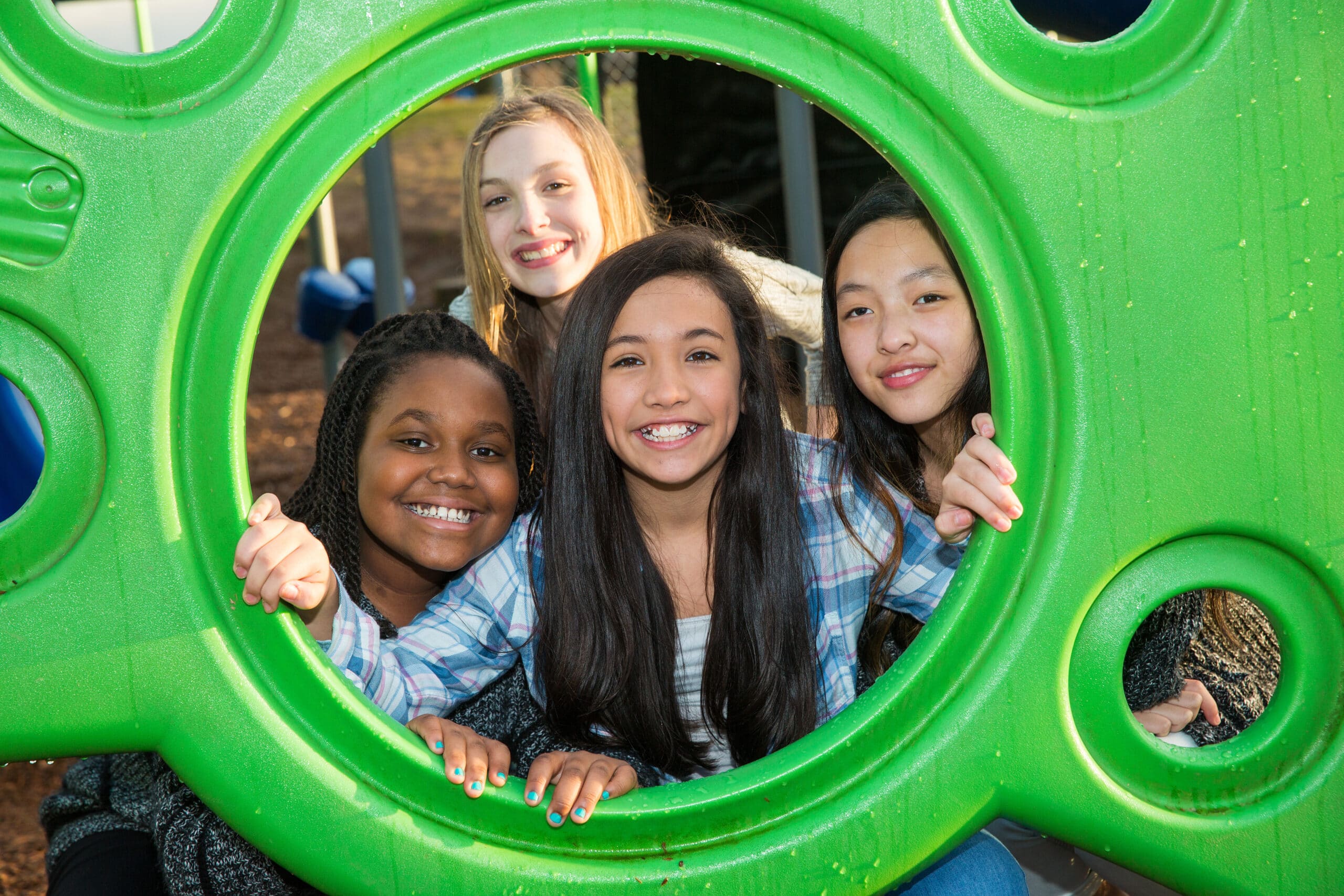 Group of four children playing together in park